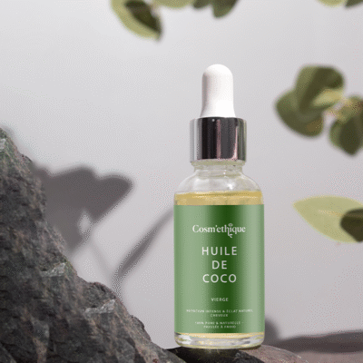 Huile de coco vierge dans une bouteille en verre avec tube