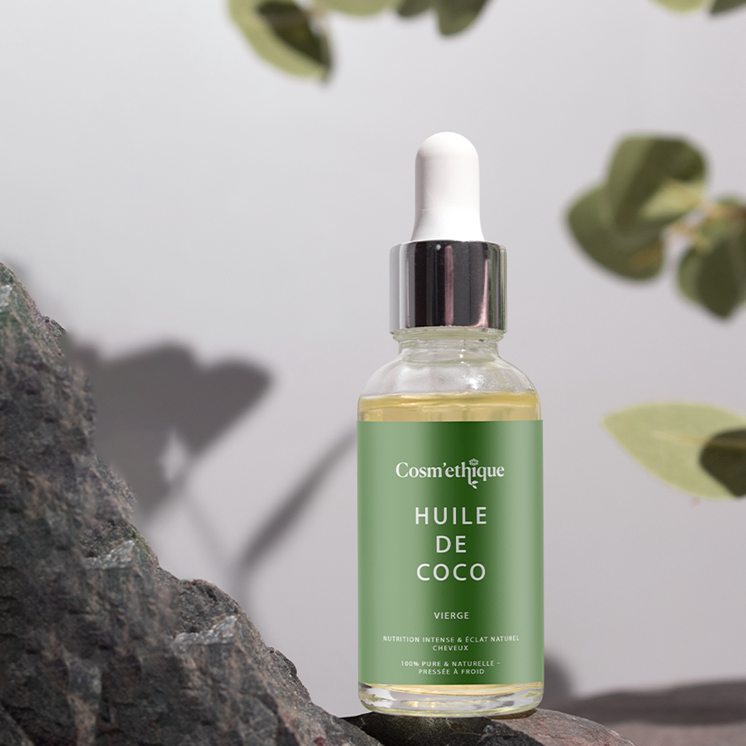 Huile de coco vierge dans une bouteille en verre avec tube