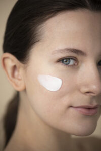 Visage d'une femme avec une pointe de crème sur la pommette
